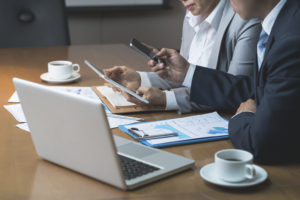 Two executives in meeting with phone and tablet